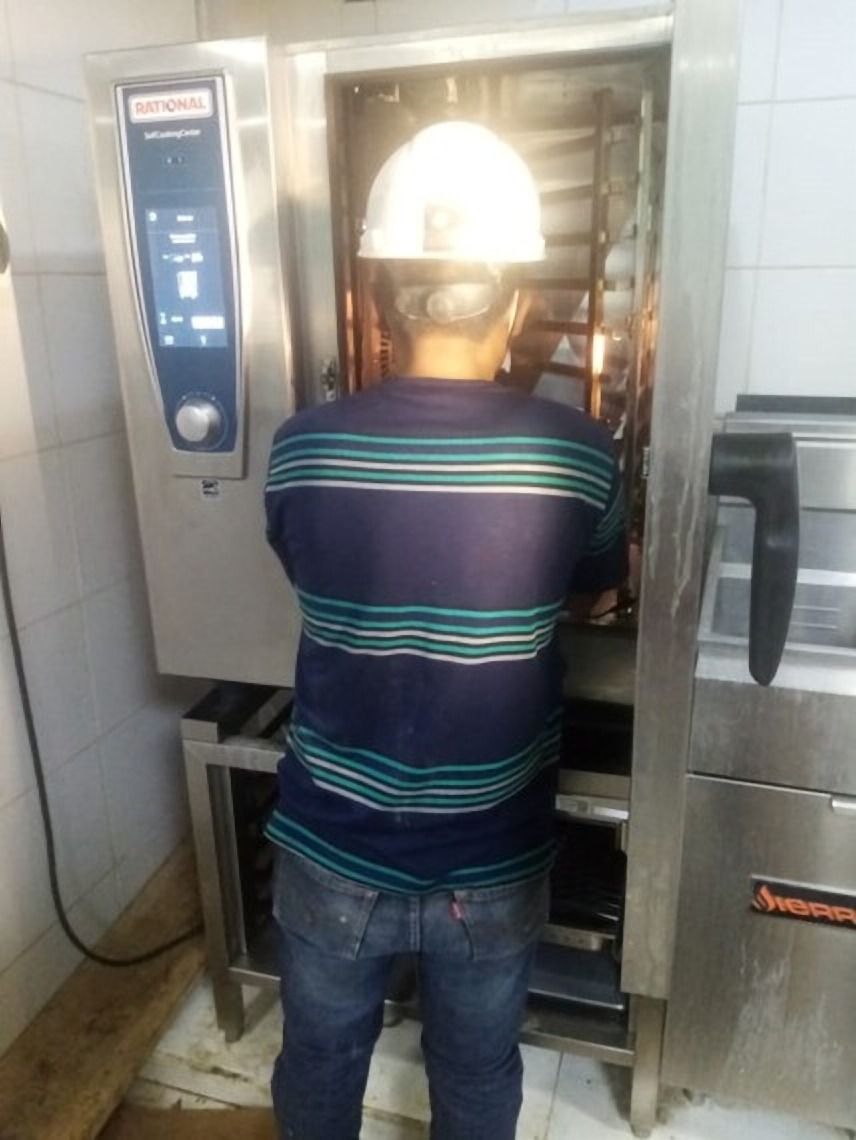 Persona con casco frente a un horno industrial