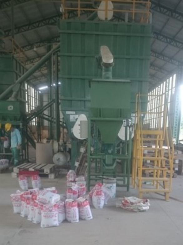 Estructura verde con tolva y sacos en la base