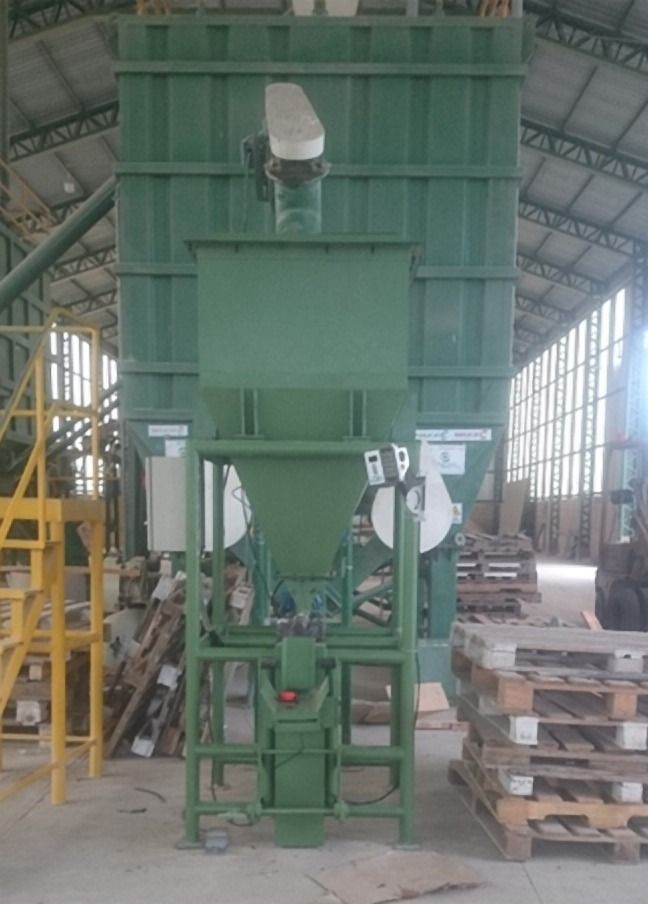 Estructura verde vertical con tolva y tarimas en la base